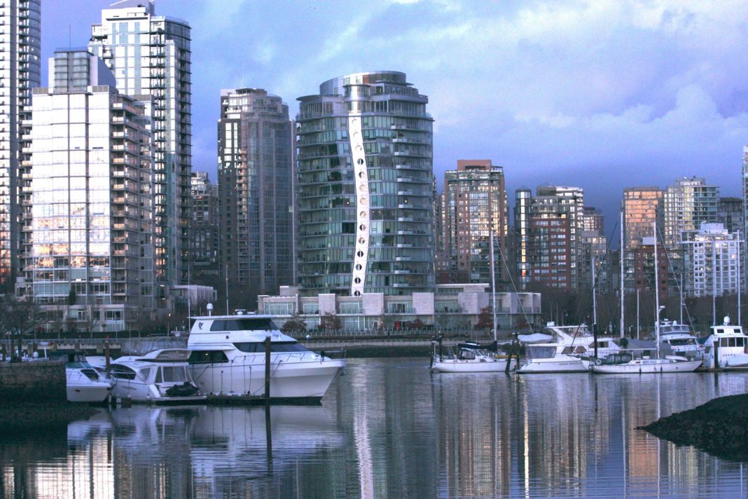 a harbor filled with lots of boats next to tall buildings